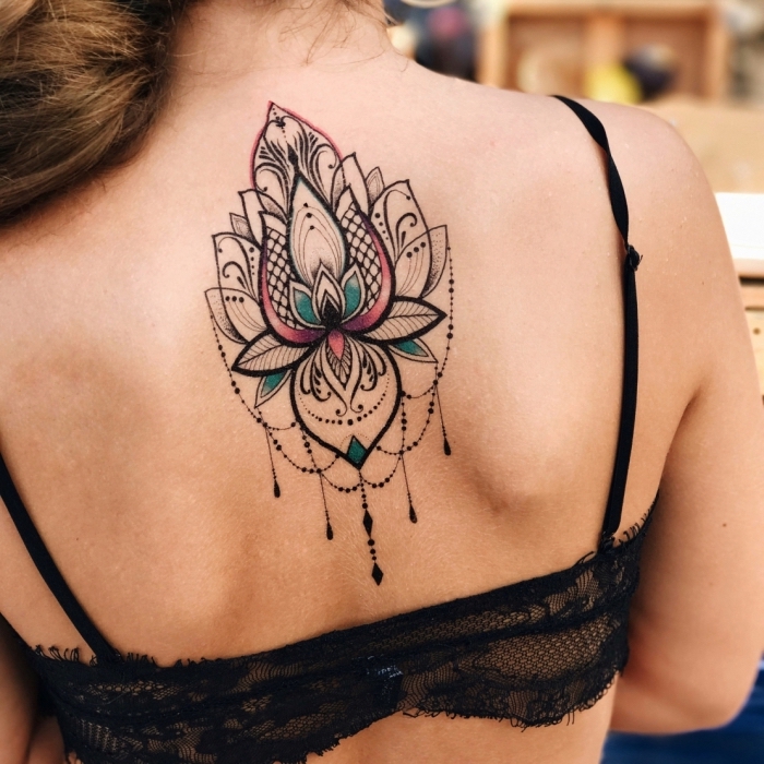 lotusblume tattoo am rücken, große tätowierung in schwarz, rosa und blau, mandala lotus