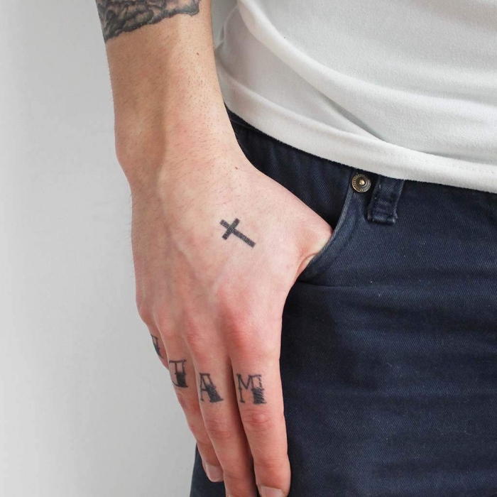 hand tattoo mann, kleiner simpler kreuz, buchstaben an den fingern, tätowierungen für männer ideen
