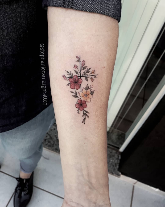 kleine tattoo motive ideen, farbige tätowierung am arm, kreuz mit floralen elementen, kleine blumen