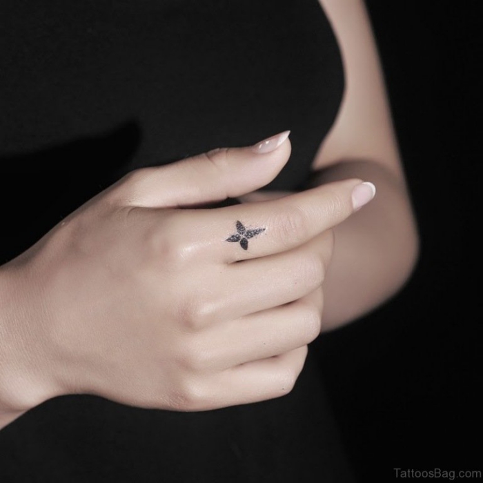 tätowierung mit kreuz als motiv, finger tattoo frau, französische nägel, kleines tattoo am zeigfinger