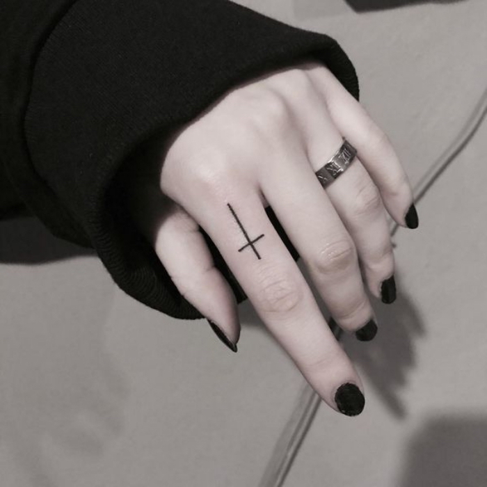 finger tattoo frau, kleines motiv, tätowierung am zeigfinger, schwarzer nagellack, silberner ring
