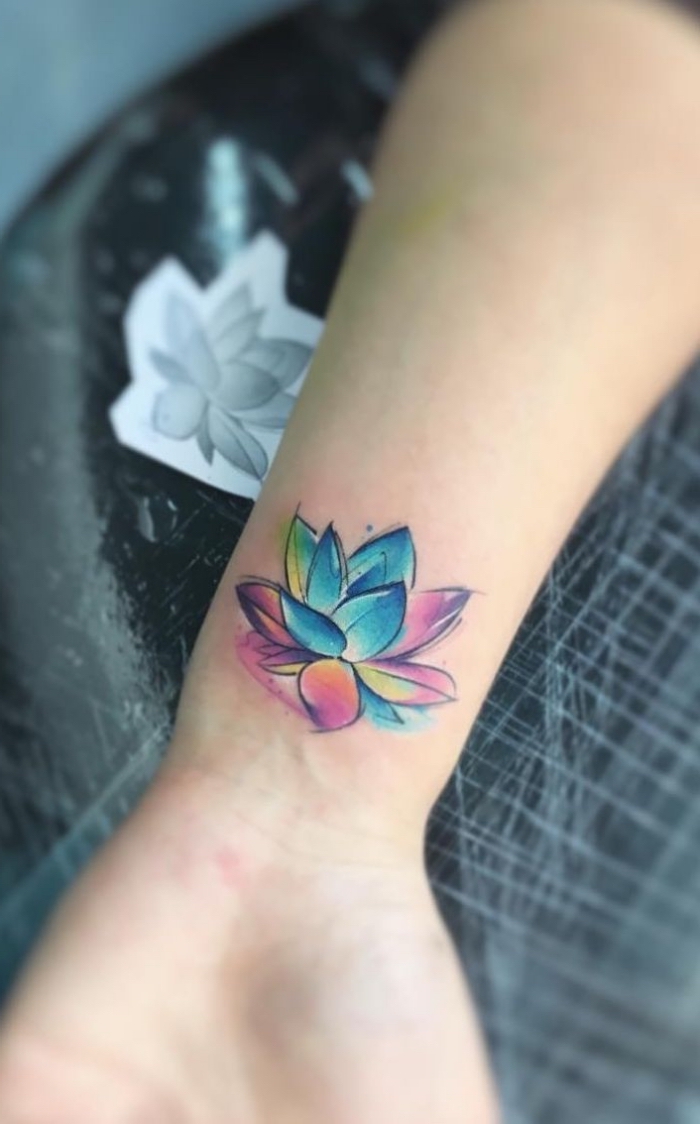 lotus tattoo am arm, kleine lotusblüte in blau, rosa und gelb, tattoo motive für frauen, blumen