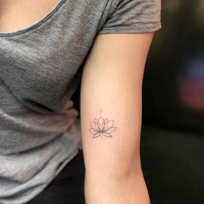 lotusblume tattoo bedeutung und designs, frau mit kleine tätowierung am oberarm, lotus