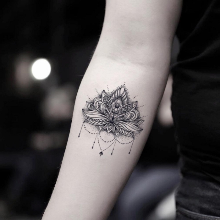 lotusblüte bedeutung, detailliertes tattoo am unterarm, schwarz graue tätowierung am arm