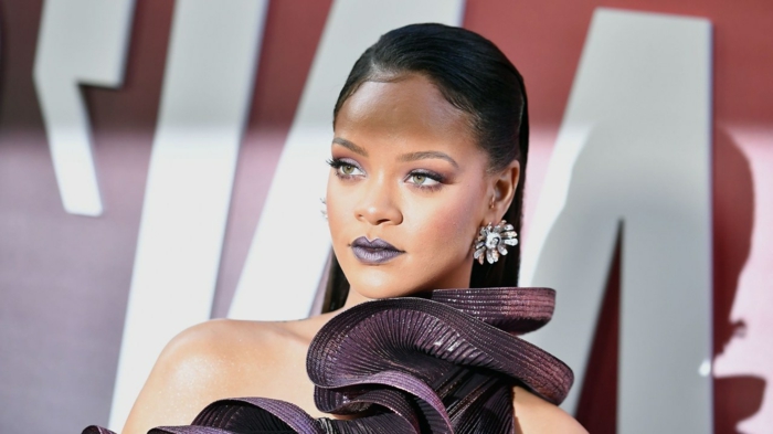 Rihanna mit glatten, langen, schwarzen Haaren und ein blauer Lippenstift, ein schwarzes Kleid