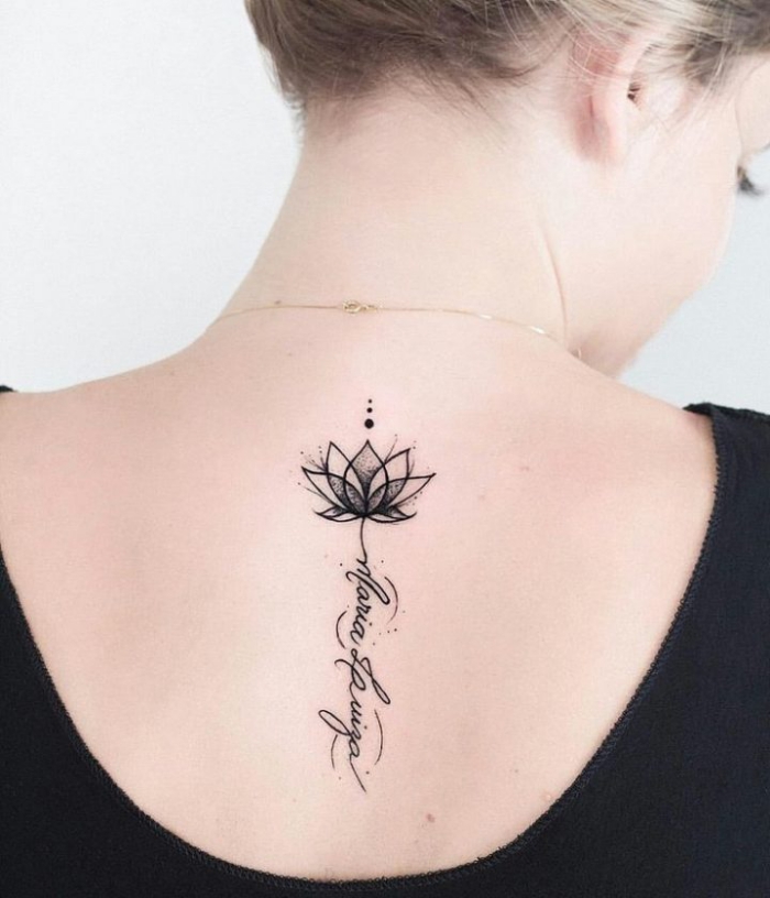 lotusblume tattoo am rücken, kleiner lotus in kombiantion mit schriftzug, blackwork tätowierung