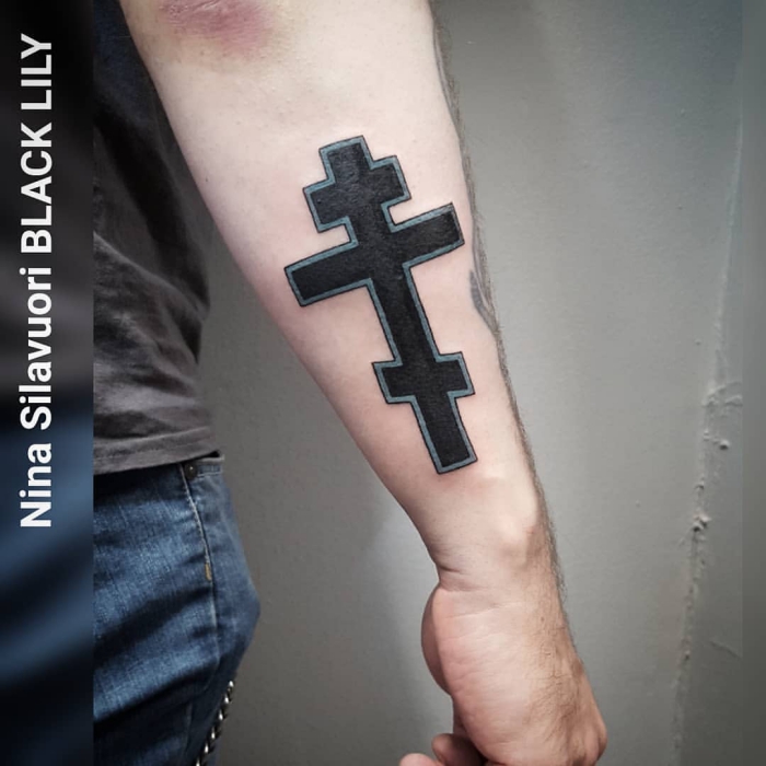 tattoo bedeutung, schwarzes kreuz am unterarm, mann mit blackwork tätowierung am arm