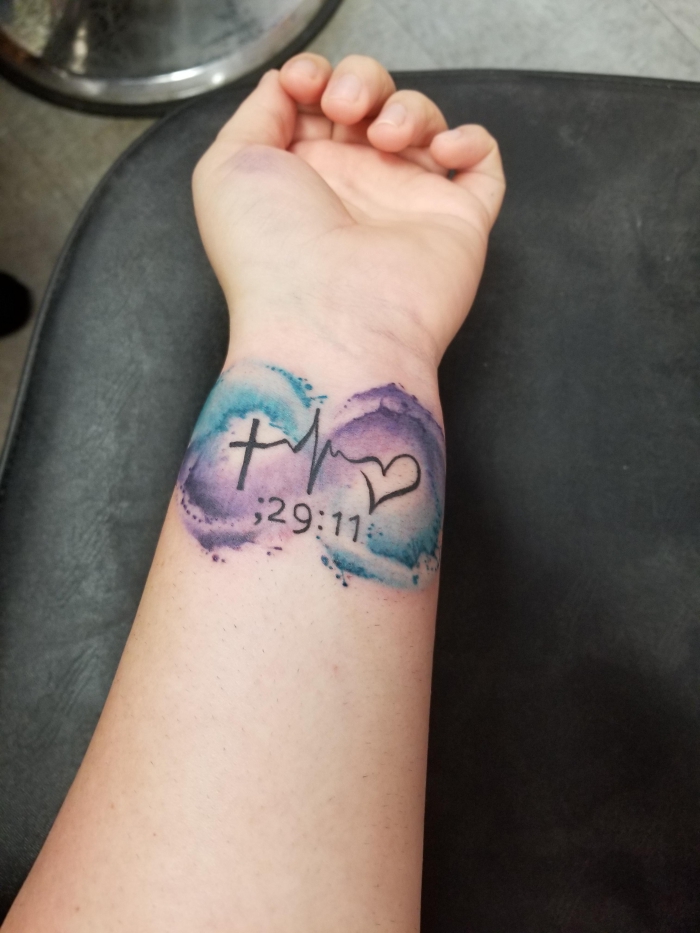 kleines wasserfarben tattoo am unterarm, tattoo glaube liebe hoffnung, unterndlischkeitszeichen in lila und blau