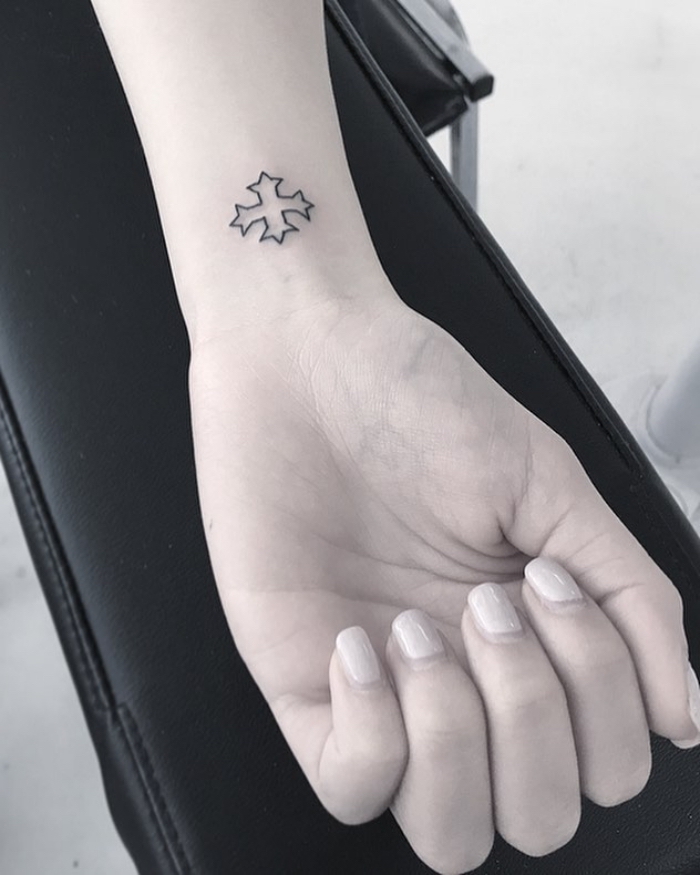 tätowierung mit kreuz als motive, kleines symbol am unterarm, tattoo ideen klein, frau