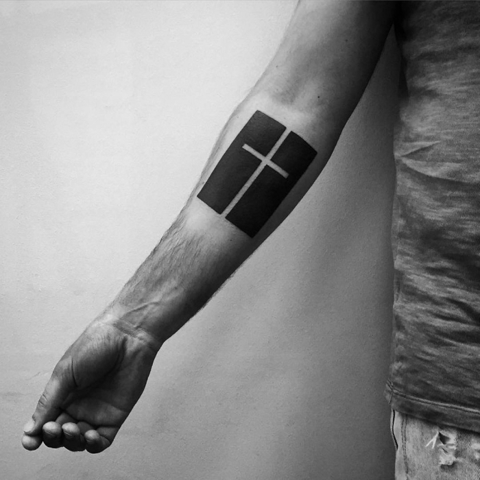 blackwork tattoo kreuz, tätowierung am unterarm, simples design, religiöses motiv, tattoos für männer