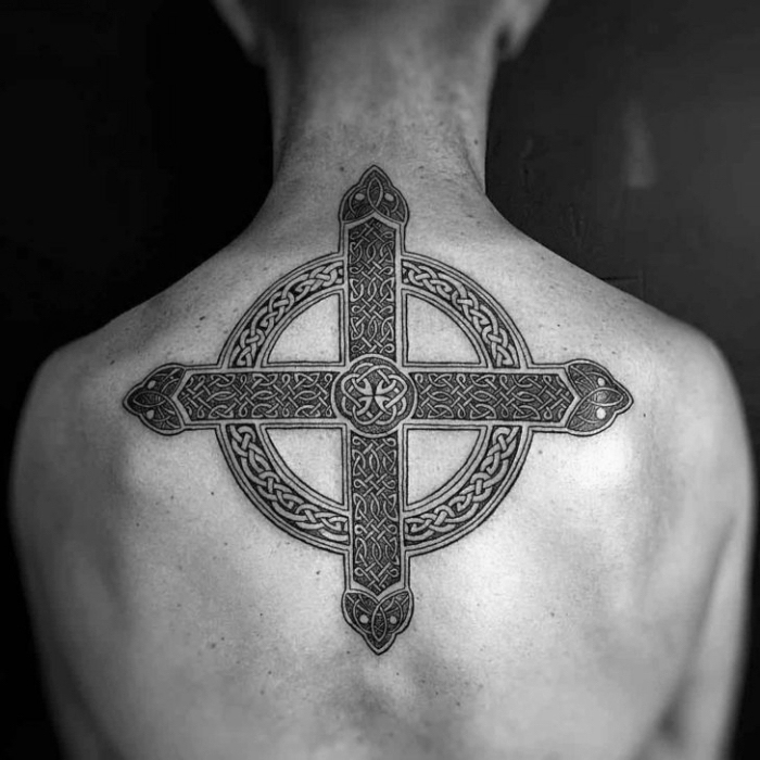 tattoo kreuz, mann mit großer schwarz grauer tätoweirung mit keltischen motiven am rücken, symbol