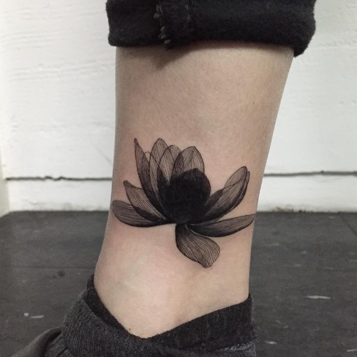 tattoo lotusvlüte, blackwork tätoweirung am bein, symbol für neuanfaang, schwarze lotusblüte