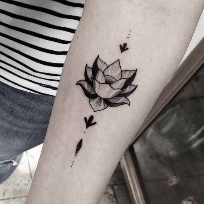 tattoo lotusblüte, frau mit blakcwork tätowierung am unterarm, lotus am arm, tattoos mit bedeutung
