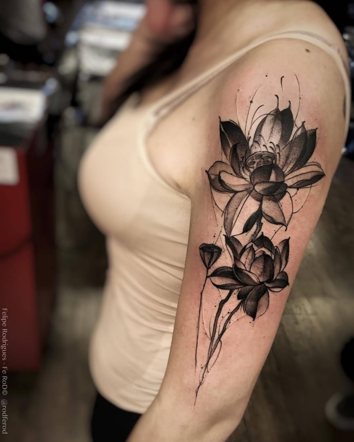 tattoo lotusblüte, große schwarze blumen am oberarm, motive für frauen, blakcwork