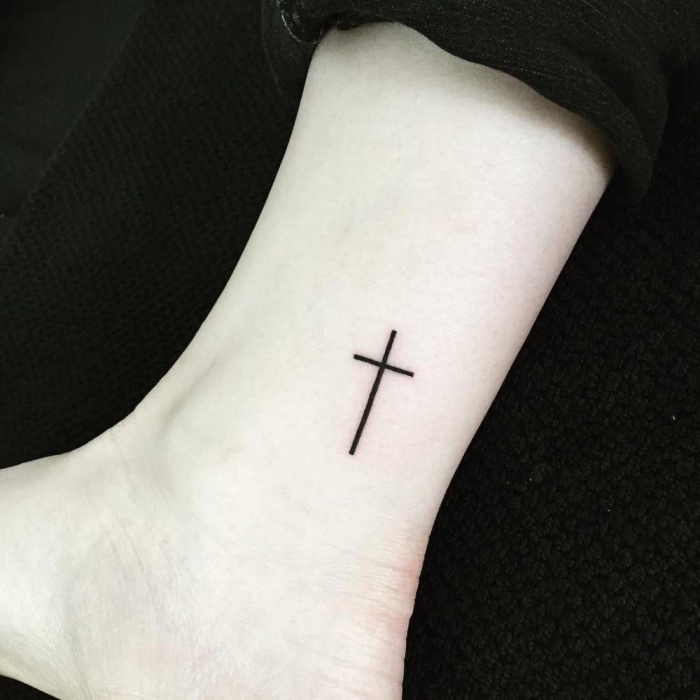 simples schwarzes kreuz am bein, tattoo motive klein, religiöse tätowierung, blackwork tätowierung