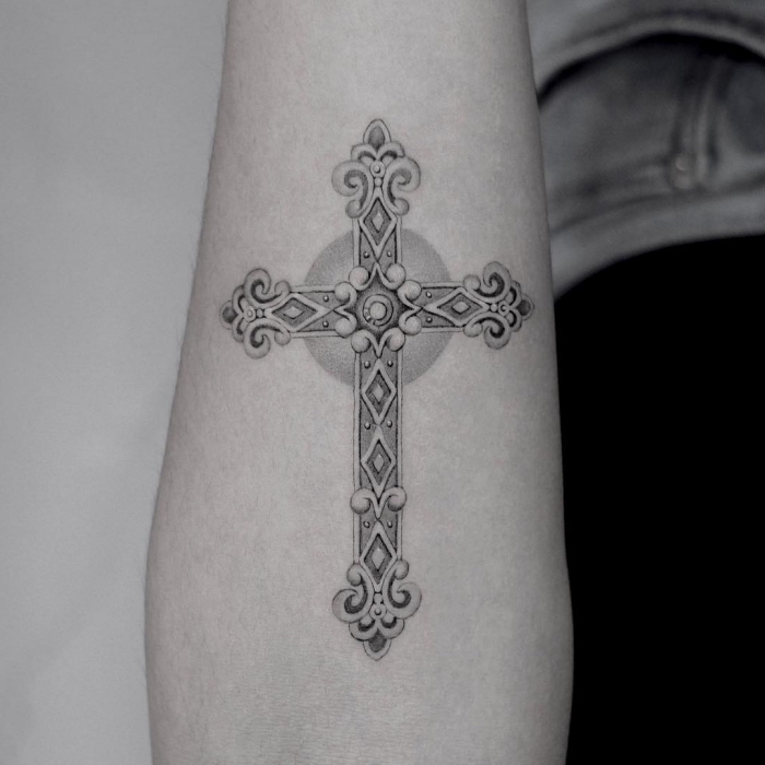 tattoo symbole ideen, detailliertes kreuz in schwarz und grau, tätowierung am unterarm