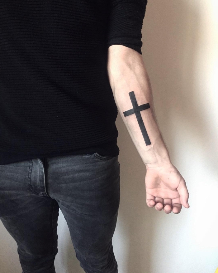 tattoo symbole ideen, blackwork tätowierung am unterarm, kreuz am arm, schwarze bluse und jeans 