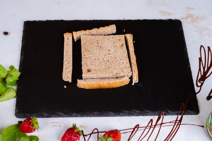 Die Ränder von allen Toastscheiben abscheiden, mit einem Nudelholz plattwalzen, French Toast Rezept 