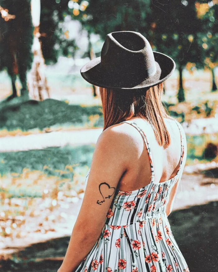 beliebte Tattoos, ein Mädchen mit weißem Kleid mit Blumenmotiven versehen und ein Hut, ein Herz Tattoo