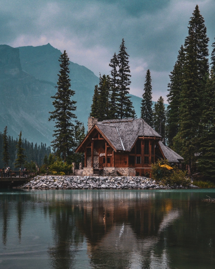 ein See und ein Blockhaus in der Mitte, ein Ferienhaus in einem Wald im Gebirge