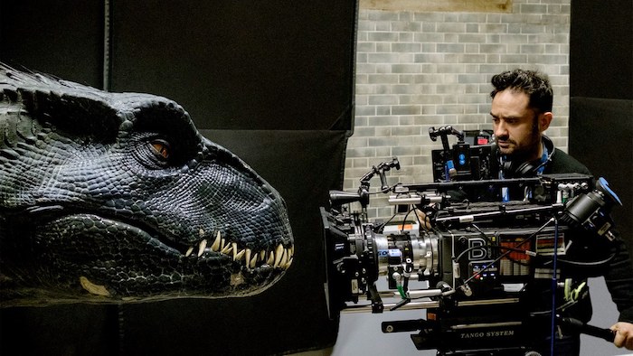 der regisseur juan antonio bayona mit einer kammer und einem schwarzen Dinosaurier mit scharfen zähnen