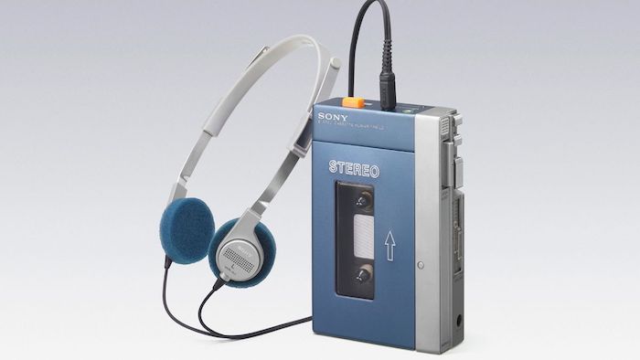 kleiner blauer walkman von sony mit kassette und blauen kopfhörern 