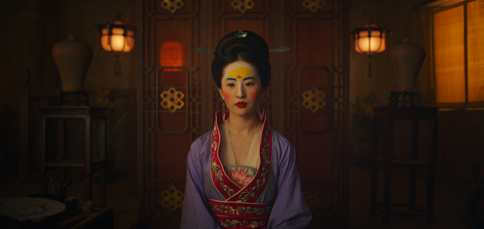 ein zimmer mit leuchten und eine junge frau mit schminke und ohrringen und violetten chinesischen kleidern