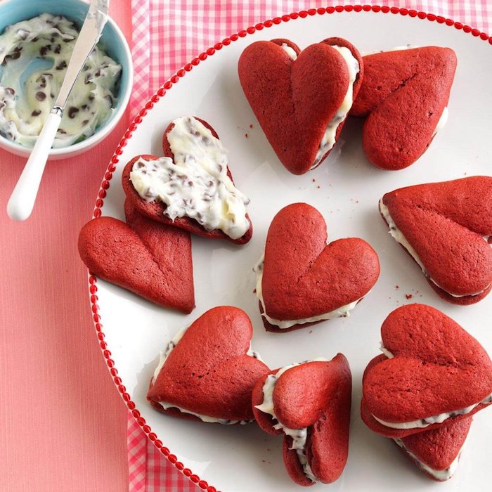 Süße Snacks für Party Gäste, rote Kekse in Form von Herzen, Vanillecreme mit Schokoladenstückchen 