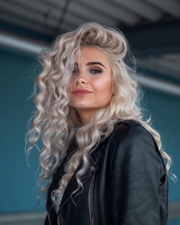 haartrends 2019, gesunde und glänzende lange blonde haare mit locken eine schöne frau lächelt