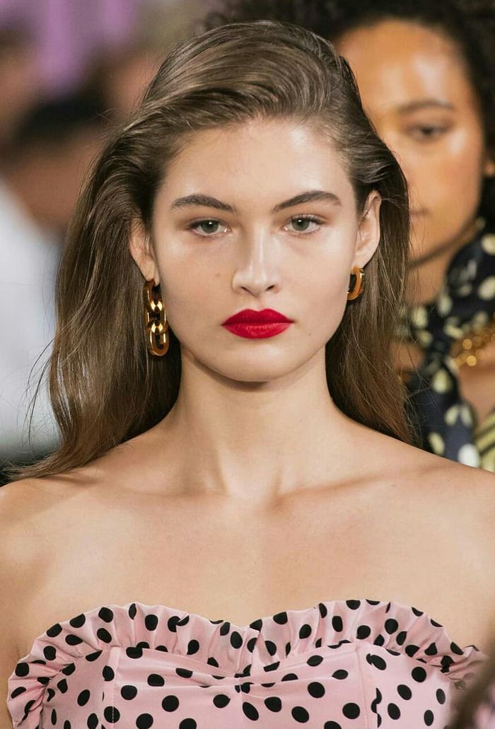 frisur trend 2019, eine model mit natürlicher haarfarbe, rote lippen, rosa kleid mit punkten