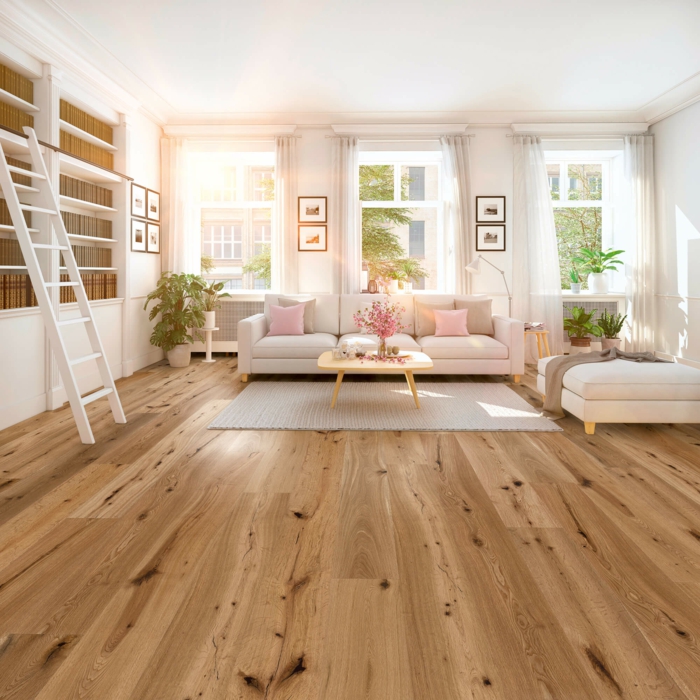 Parkettboden, ein beiger Sofa mit rosa Kissen, grauer Teppich, Holz als natürlicher Baustoff