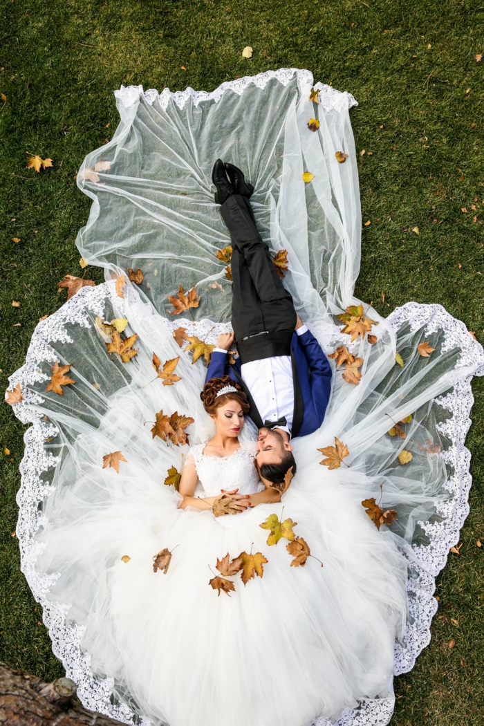 ein prächtiges Brautkleid und ein Bräutigam in blauem Kostüm, Hochzeit im Herbst