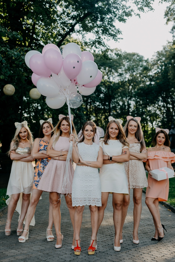 JGA Fotoshooting, eine Reihe von Mädels, die sich auf die Hochzeit vorbereiten, weiße und rosa Kleider