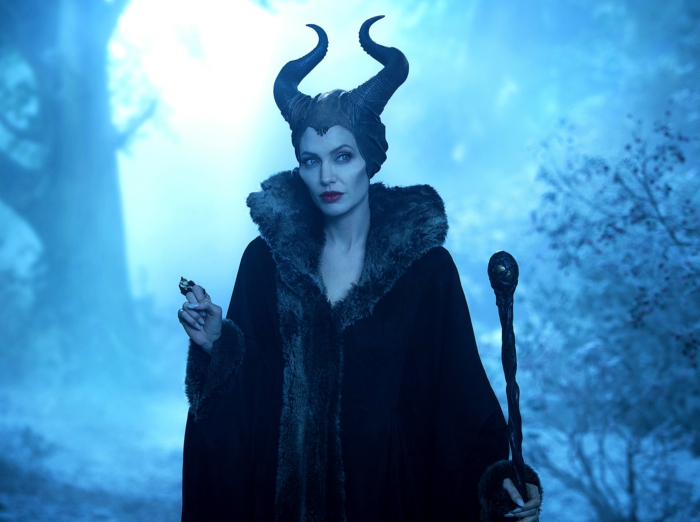 Maleficent trägt ein schwarzer Mantel in einem Wald, sie hat zwei spitze Hörner
