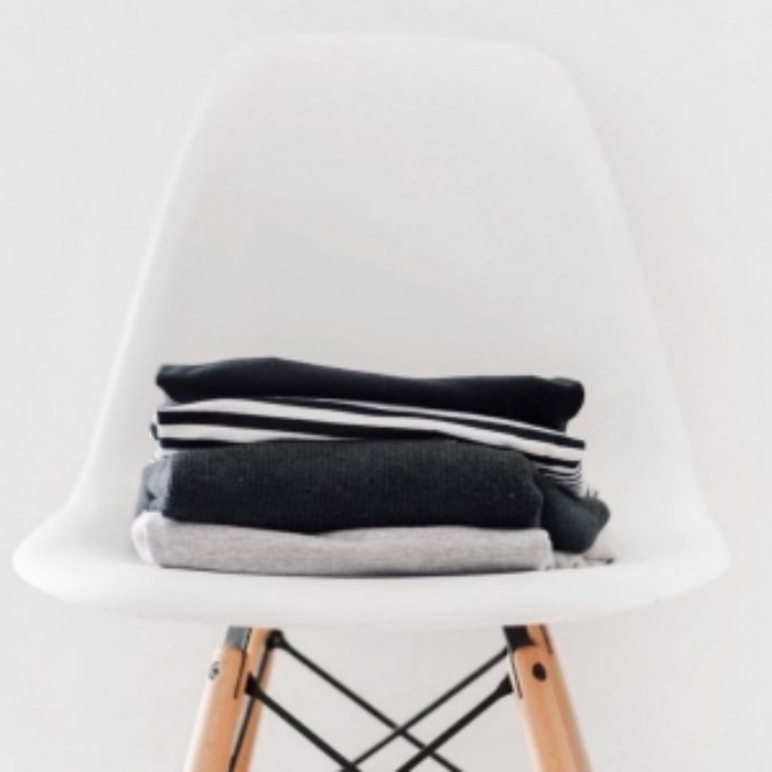 ausmisten minimalismus, ein weißer stuhl mit kleidung darauf, schöne dekor ideen zu hause