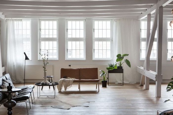 minimalistische einrichtung, wenige dekoelemente, weißes zimmer, braunes doppelsofa