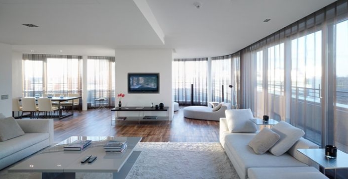minimalistische möbel, großes wohnzimmer mit einer wand im mittelpunkt, fernseher, sofa mit kissen