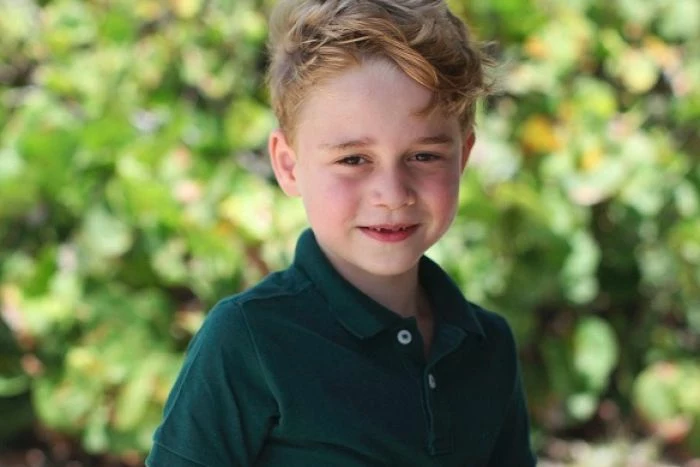 Prinz George ist ein niedlicher Junge mit blonden Haaren und eine grüne Bluse