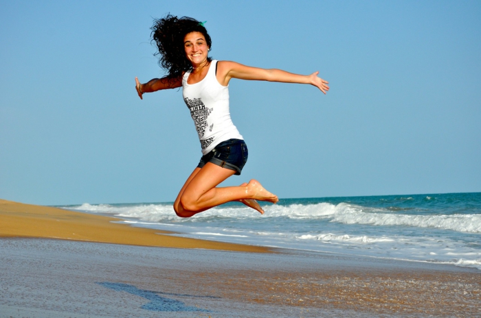 ein schlankes Mädchen springt am Strand, sie hat eine Strandfigur
