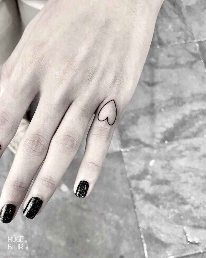 Kleines Herz Tattoo am kleinen Finger, schwarzer Nagellack mit Glitzer, Motive für Finger Tattoos 