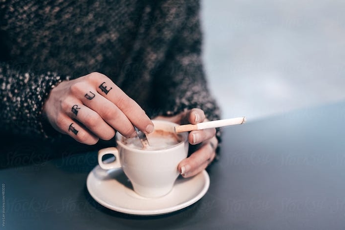 Finger Tattoo an den Fingern, französische Maniküre, Tasse Kaffee und Zigarette 