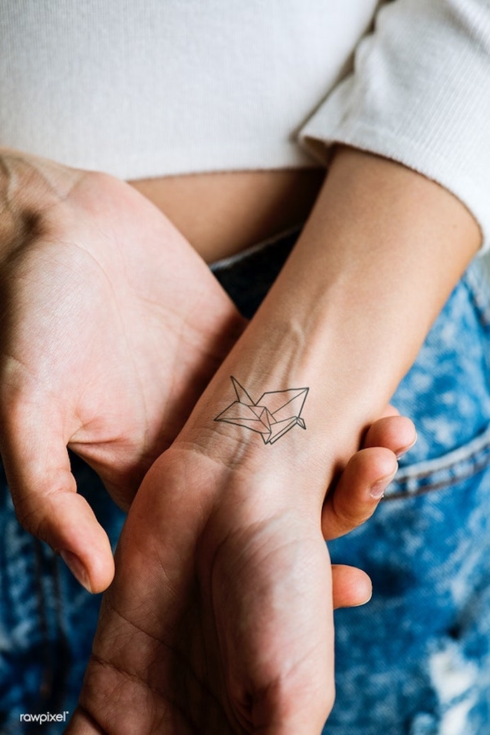 Kleines Origami Tattoo am Handgelenk, coole Tattoos für Hand, Jeans und weiße Bluse