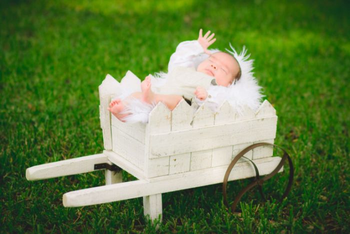 taufdeko ideen baby liegt in einem weißen stück, garten deko und fotosession vom jungling