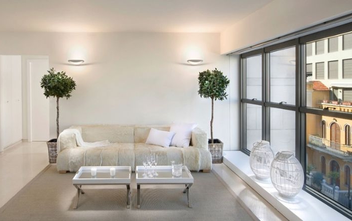minimalistische möbel, dezentes champagner weiß sofa, zwei grüne pflanzen, vasen am fenster