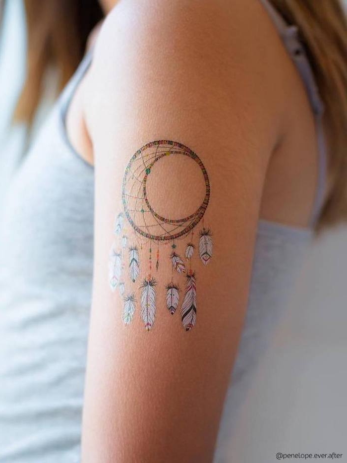 Farbiges Traumfänger Tattoo am Oberarm, Dreamcatcher mit weißen Federn, Arm Tattoos für Frauen 
