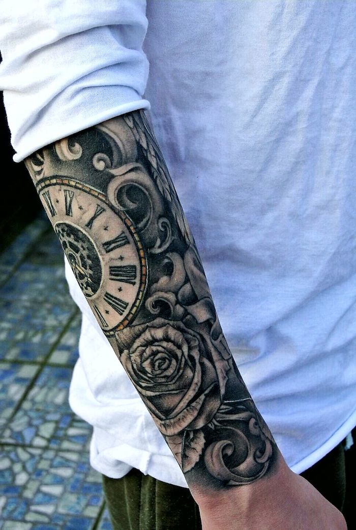 Tattoo am ganzen Unterarm, Uhr Mechanismus und Rose, weißes Shirt und grüne Hose 