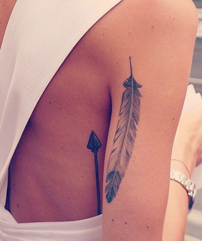 Feder Tattoo am Oberarm, Pfeil Tattoo am Rücken, weißes rückenfreies Kleid, Tattoos für Frauen 