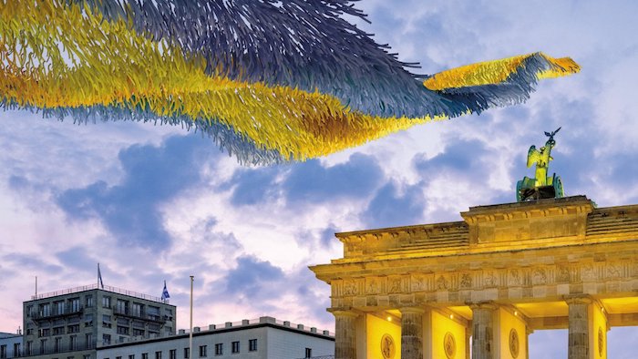 himmel mit vielen wolken, brandenburger tor in berlin, die kunstinstallation freiheitswolke mit vielen gelben und blauen zetteln mit wünschen