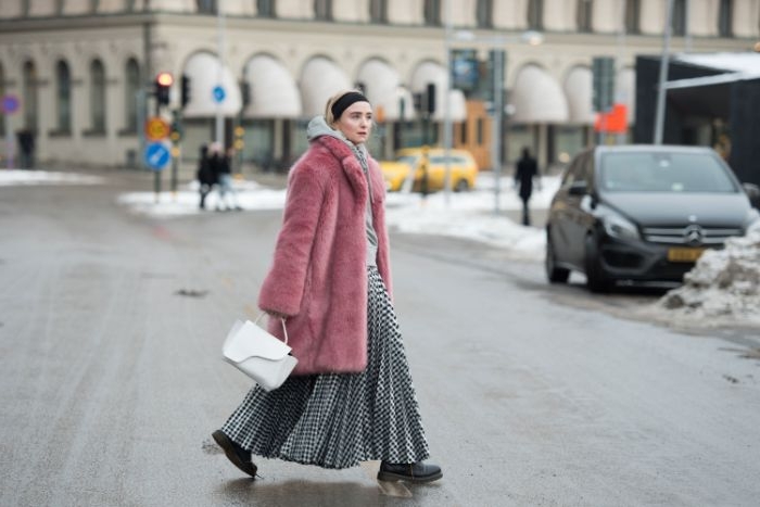 skandinavische mode für jede saison, eine frau mit langem rock mit plisseen, rosa flauschiger mantel