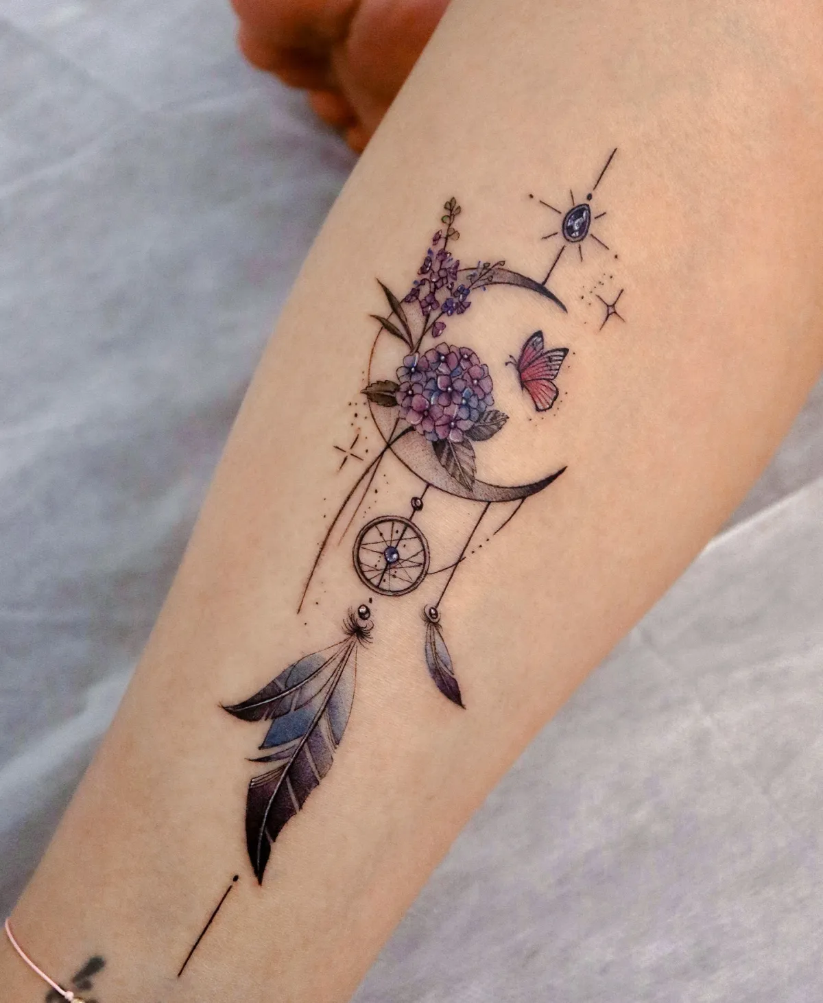 halbmond tattoo mit blumen und schmetterlingen